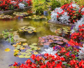 Delightful landscaped and floral park Butchart Gardens on Vancouver Island. Small pond, overgrown with flowers