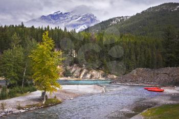 Red boats of a kayak on coast of the mountain river in Canada