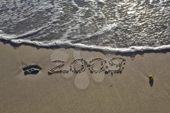 Sandy beach on coast of Mediterranean sea with an inscription on sand 2009