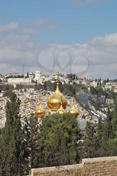 Magnificent gold domes of orthodox church in Jerusalem. Jerusalem on hills and the cloudy sky
