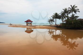 Sandy beach on Koh Samui. Swimwear wooden gazebo beautifully reflected in the water
