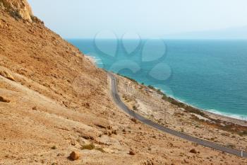 Picturesque road along the coast of the Dead Sea. In the distance moving car