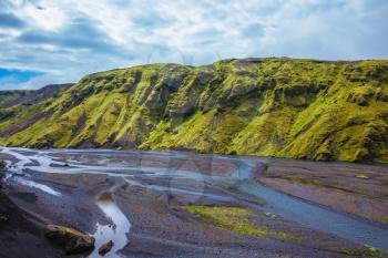 Picturesque basalt hills covered with green grass and moss-polar. At the bottom of the canyon flowing streams lot. Canyon Pakgil in Iceland