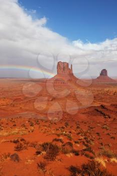 Rainbow in a red desert. The famous Mittens in Monument Valley after the rain