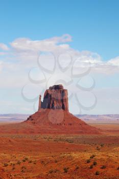 The famous Mittens in Monument Valley. The cliffs of red sandstone on the background of the cloudy sky