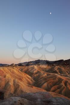  Moon over sand waves of the famous Zabriskie - Point.  Pink sunset in Death Valley.