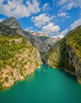 White catamarans and motor boats are sailing with tourists on turquoise water of the river Verdon. National park Merkantur, France