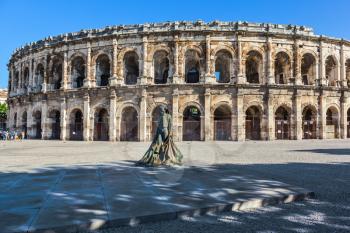 Roman amphitheater in Nimes, Provence. Monument to bullfighter installed in the square