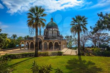 The dome of basilica is surrounded by a gallery. Church Sermon on the Mount - Mount of Beatitudes. Subtle shade of palms and cypresses