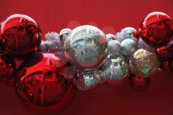 Gorgeous garland of Christmas decorations. Bright red and silver glass balls on a red background. Merry Christmas!