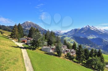 Gorgeous weather in the resort town of Leysin in the Swiss Alps. Picturesque gentle alpine meadows and rural houses chalets