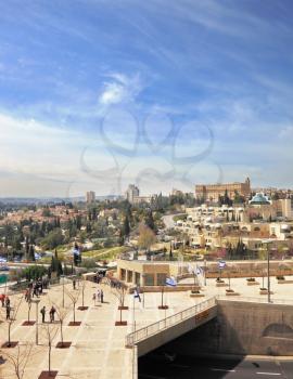 Walk along the walls of ancient Jerusalem. View of the New Jerusalem - modern buildings and people walking