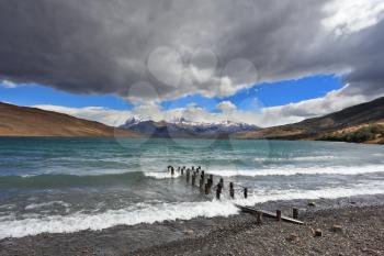  National Park Torres del Paine in Patagonia, Chile.  Storm clouds and strong winds in Laguna Azul. Boat dock on the lake