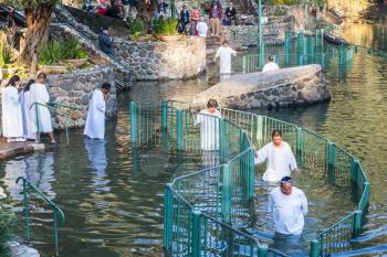 YARDENIT, ISRAEL - JANUARY 21, 2012: Christian pilgrims enter Jordan River waters. They make a baptism ceremony in honor of Jesus Christ's baptism here