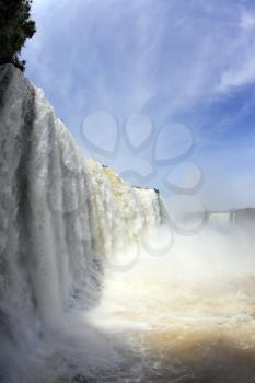 The most high-water waterfall in the world - Iguazu. White whipped foam of water and a thin mist over the water. Photo taken by lens Fisheye