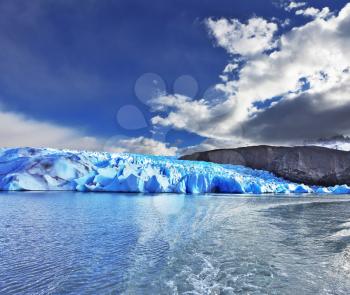 Journey to the End of the World. Chilean Patagonia in the sunlight. Blue Ice Glacier Gray is reflected in the lake