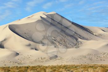 Eureka - a huge sand dune at sunrise. A thin ridge of dunes pale yellow. California, USA