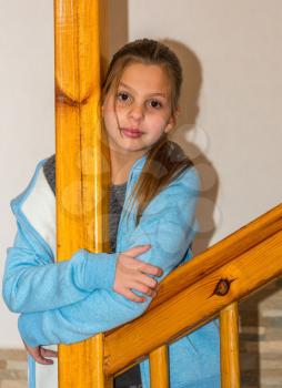 Family children's party. Elder sister Alice posing near the wooden stairs.