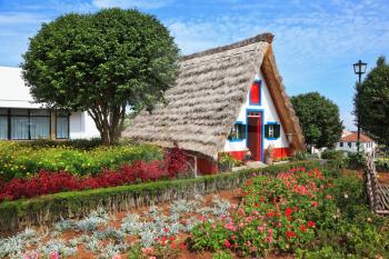 Old house-museum of the first settlers on the island of Madeira. Charming white cottage with a thatched roof gable
