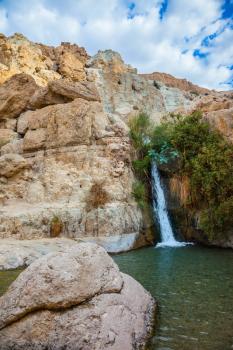   Adorable waterfall among rocks parched desert. The journey through the national park and reserves Ein Gedi, Israel