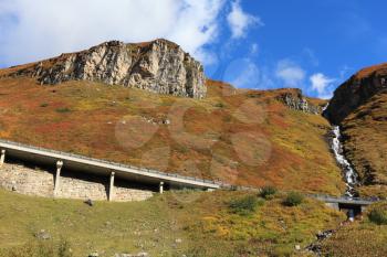 The platform supports and fences the highway. Snow-capped Alps in beautiful autumn day