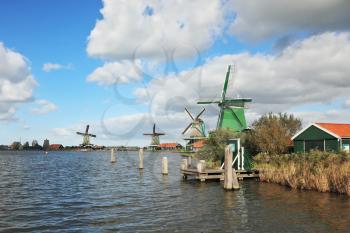 Countryside - an ethnographic museum in the Netherlands. Four windmills on the banks of the channel overflowing