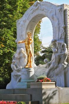 Elegant gilded statue of Johann Strauss, playing the violin in white marble arch