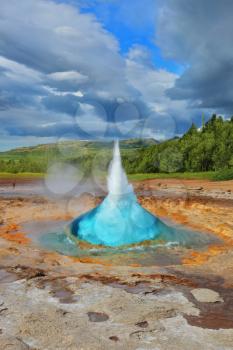 Summer in Iceland. Magnificent geyser Strokkur. Fountain Geyser throws azure water every few minutes