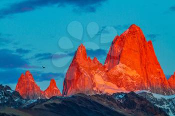 Sharp tops fantastically cliffs Fitz Roy illuminates the crimson sunset. Patagonia in February