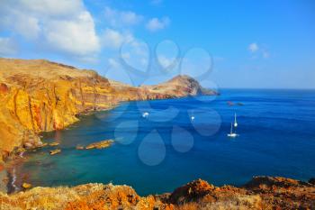  Quiet ocean cove on the island of Madeira. White sailing yachts lit sunset. Calm on the Atlantic Ocean