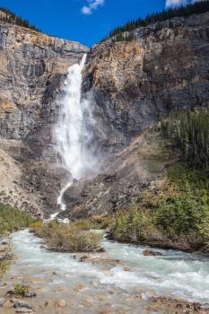 Rocky Mountains of Canada. Yoho National Park. Autumn waterfall forms full-flowing water flow of pearl color