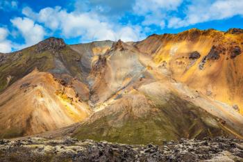 Multi-colored mountains from rhyolite are lit with the July sun. Travel to Iceland in the summer. National park Landmannalaugar