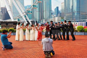 HONG KONG, DECEMBER 11, 2014: Hong Kong Special Administrative Region. Youth wedding photographed in a public park near the ferris wheel.  The modern city on the ocean coast