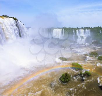  White whipped foam of water and a thin mist over the water. Magnificent rainbow bent in mist. The most high-water waterfall in the world - Iguazu. The picture is taken by lens Fisheye