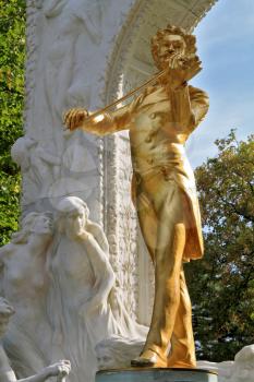 Park in Vienna.  Elegant gilded statue of Johann Strauss, playing the violin in white marble arch