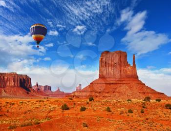 Unique cliffs of red sandstone mitts. High in the clouds flying balloon.  Red Desert Navajo reservation in the USA