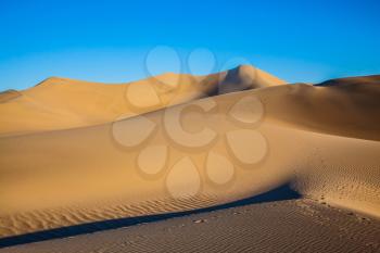  Bizarre twists of orange sand dunes. Mesquite Flat Sand Dunes. Sunny morning in a picturesque part of Death Valley, USA