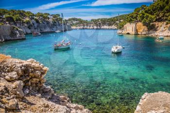 National park of Calanques in Provence. The picturesque gulf with turquoise water at coast of the Mediterranean Sea. Graceful sailing yachts in the sea fjord