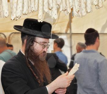 BNEI- BRAK, ISRAEL - SEPTEMBER 17, 2013: Traditional market before the holiday of Sukkot. Religious Jews in black hats and skullcap of carefully selected ritual fruits and plants
