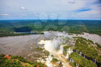 Devil's Throat - largest waterfall of the Iguazu Falls. Iguazu River spreads widely among the dense tropical forests. Picture taken from a helicopter