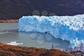 The woman - tourist admire the white-blue icy splendor. Giant lake Perito Moreno glacier