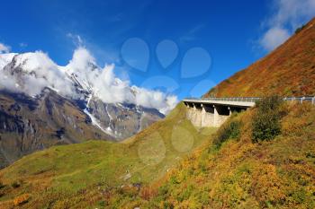 Snow-capped Alps in a beautiful autumn day. The platform supports and fences the highway