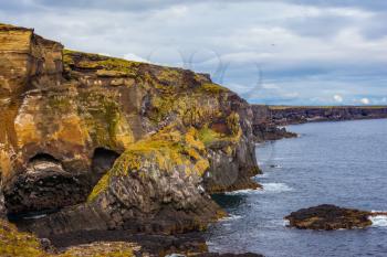 Scenic fjords on a cloudy summer day. Rocks covered with moss. Gorgeous Iceland. North sea coast