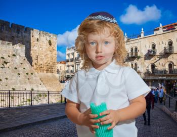  Little boy with long blond curls and blue eyes. Adorable Jewish child in a blue yarmulke. Jerusalem, the city of King David