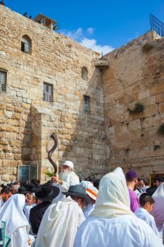 JERUSALEM, ISRAEL - OCTOBER 12, 2014:  The old man blows the shofar. The Jews of tallit hold four ritual plants. Religious Jews came to the Western Wall of the Temple