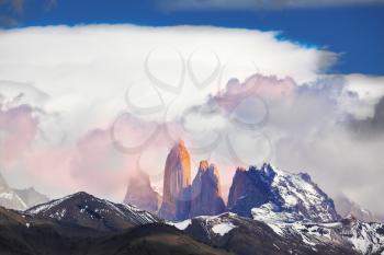 Three rock Torres del Paine lit pink rays of sunset. Patagonia