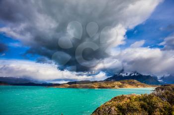 A giant cloud over the picturesque lake Pehoe. Concept of ecotourism. Chile, Patagonia. Torres del Paine National Park - Biosphere Reserve