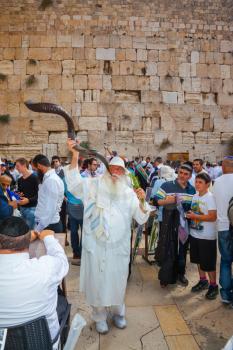 JERUSALEM, ISRAEL - OCTOBER 12, 2014:  The Jews of tallit hold four ritual plants. Religious Jews came to the Western Wall of the Temple. The old man blows the shofar