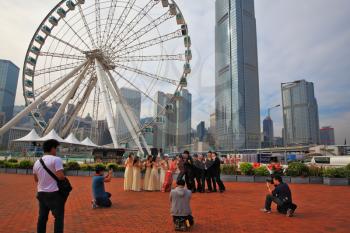 HONG KONG, DECEMBER 11, 2014: Hong Kong Special Administrative Region. The modern city on the ocean coast. Youth wedding photographed next to a huge ferris wheel