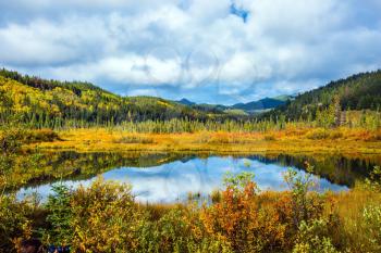 Charming Patricia Lake amongst the evergreen forests and distant mountains. Warm autumn in the Rocky Mountains of Canada
